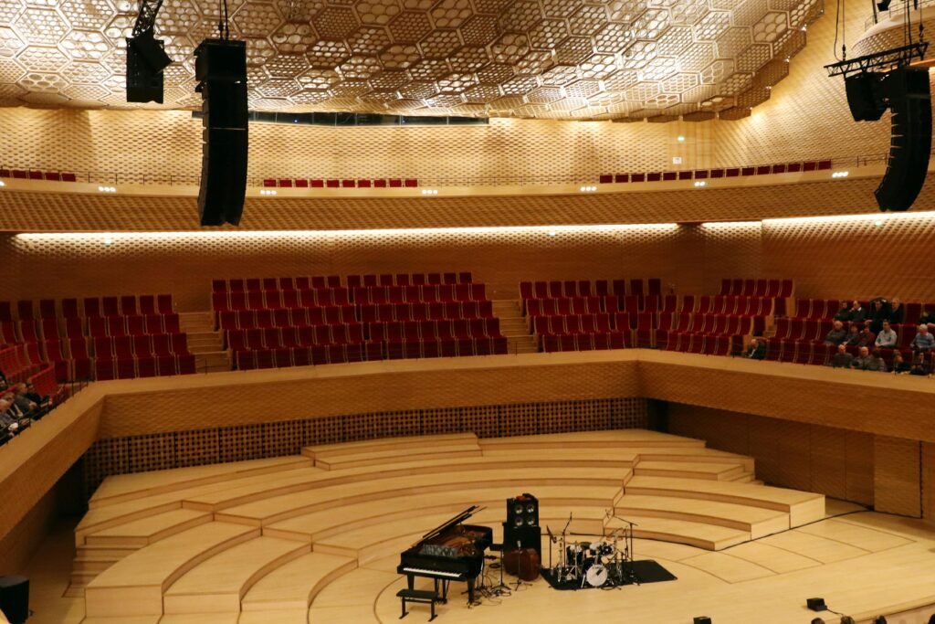 Spacious concert hall interior featuring a grand piano and red seating in Boulogne-Billancourt, France.