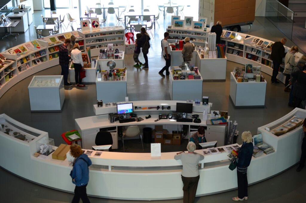 A bustling indoor bookstore with customers browsing books and interacting with staff.