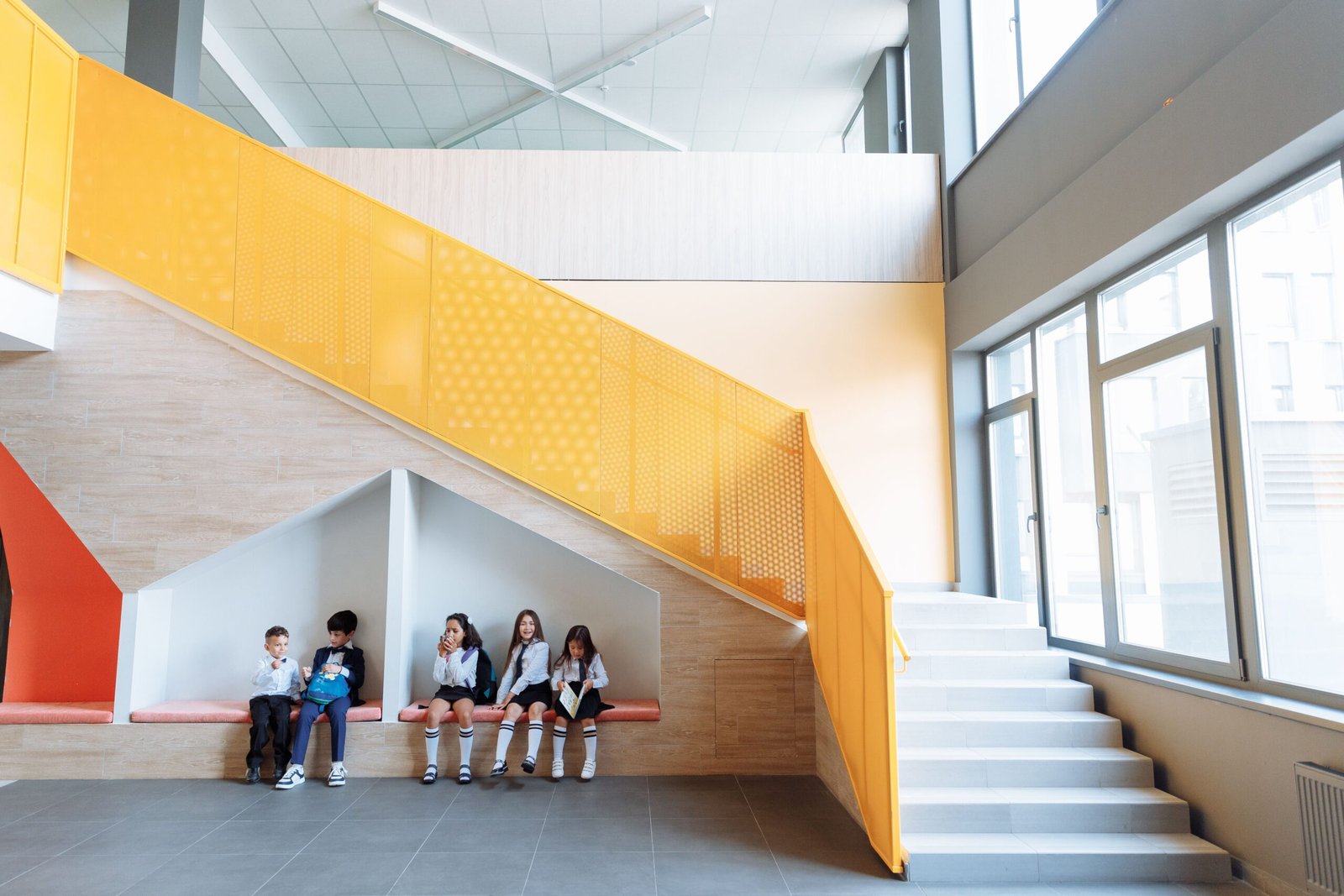 Ecoliers assis dans le hall d'une école.